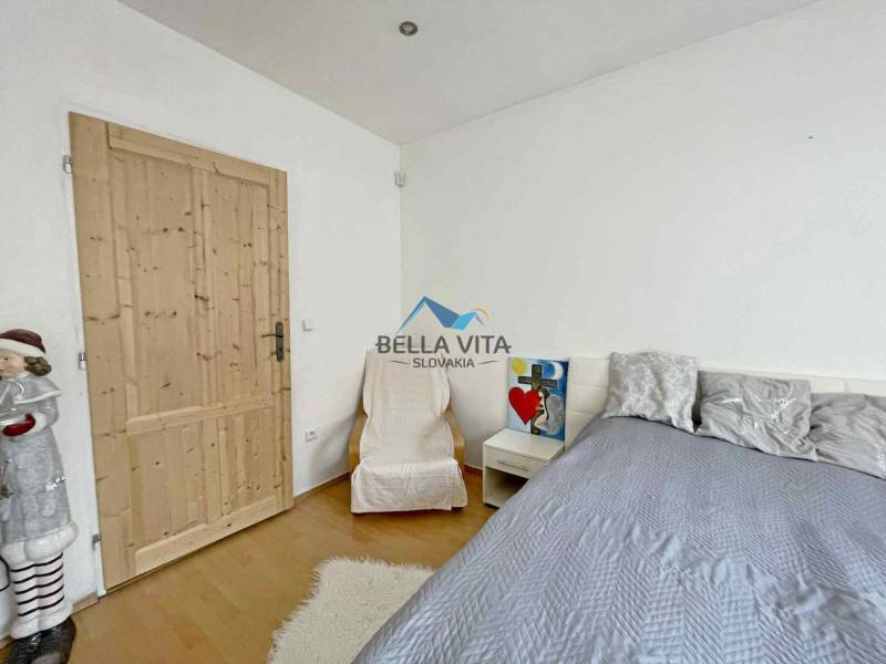 Bedroom in a family house with a wood-decor floor, decorations, and a bed.