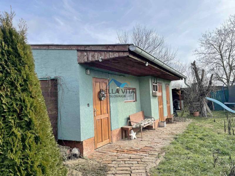 A family house on Hodská Street in Galanta with a lawn and a wooden bench.
