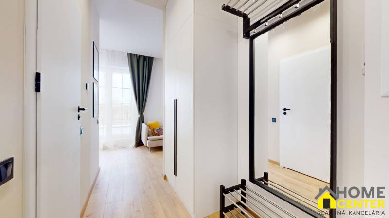 A bright hallway with wood-patterned flooring and white walls in a studio apartment.