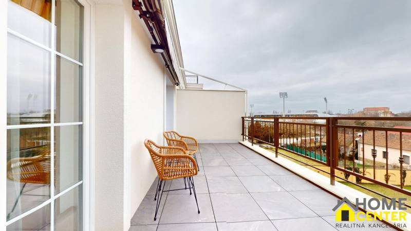 The balcony of a 1-room apartment in Komárno with a view of the city sports facilities.