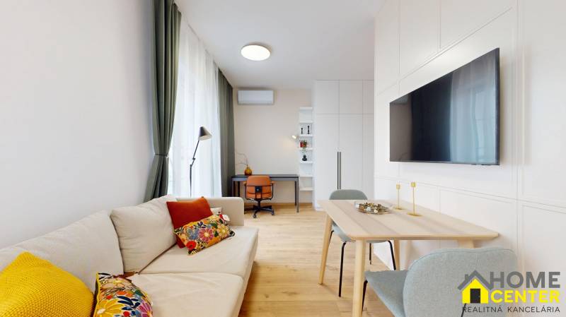 A bright living room with wood-patterned flooring, a sofa, and a dining table in a studio apartment.