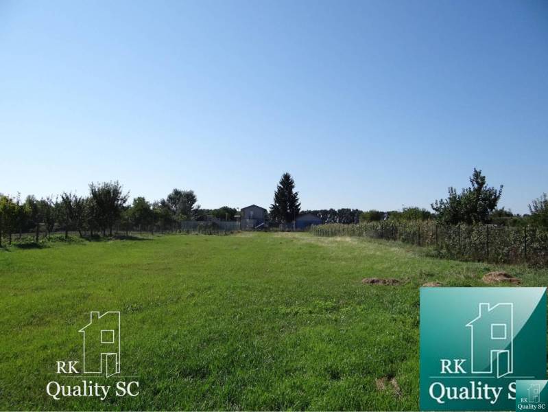 A residential plot on Vrbová Street in Jelka surrounded by greenery and fencing.