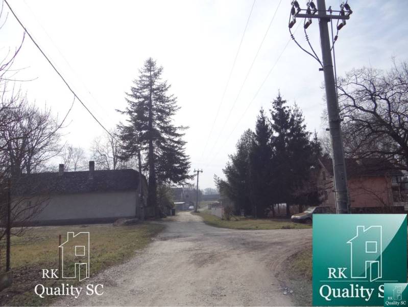 A country road in the Old Port of Gabčíkovo, lined with houses and trees, plots - residential.