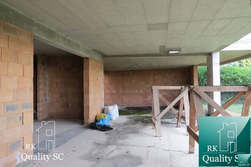 An unfinished family house in the stage of rough construction with ceramic bricks and a concrete ceiling.