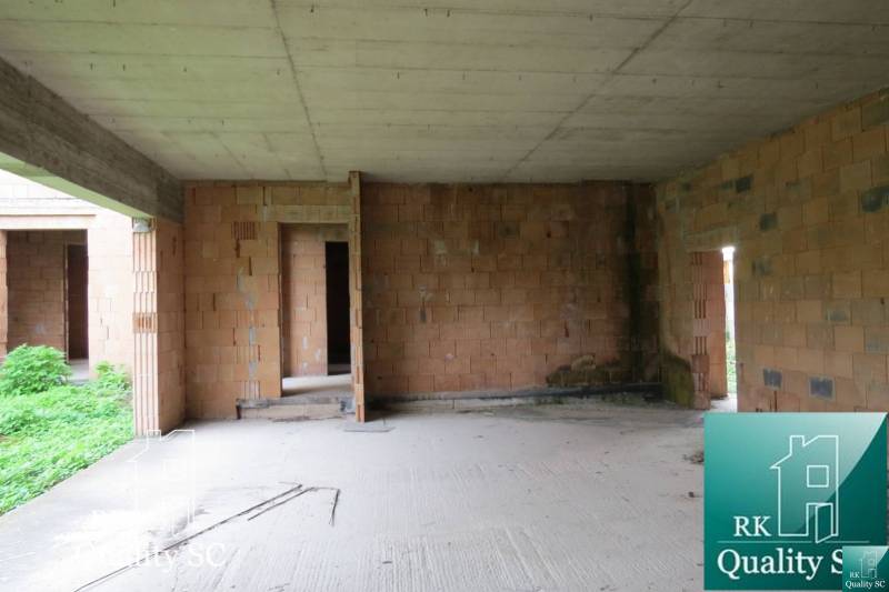 The interior of a family house, unplastered brick walls, view into an incomplete room.