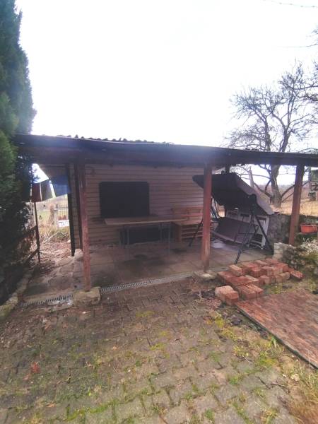 A shelter from gardens in Nové Mesto nad Váhom with wooden pillars and stored bricks.