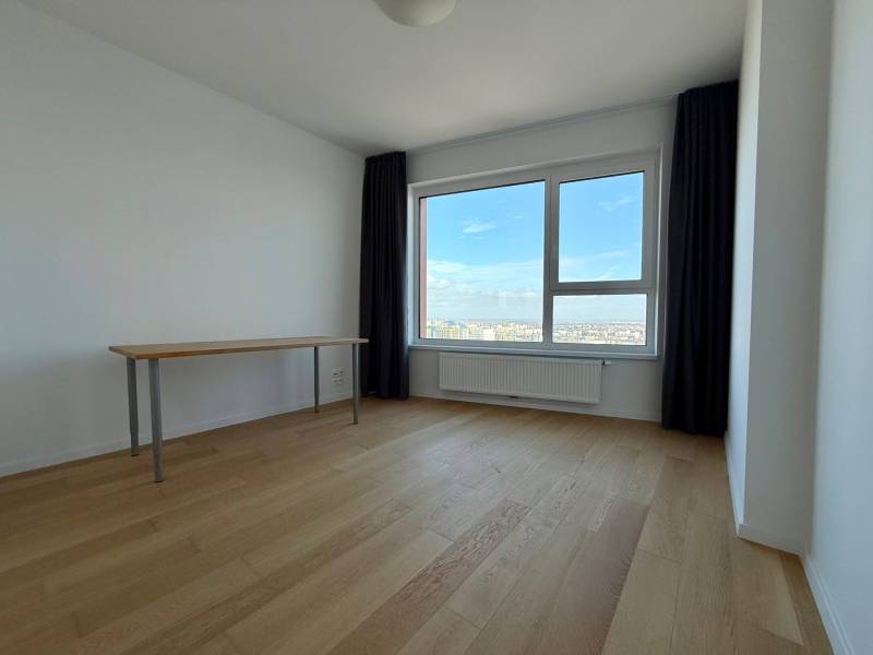 A room in a 3-room apartment with wooden decor and a large window with a view.
