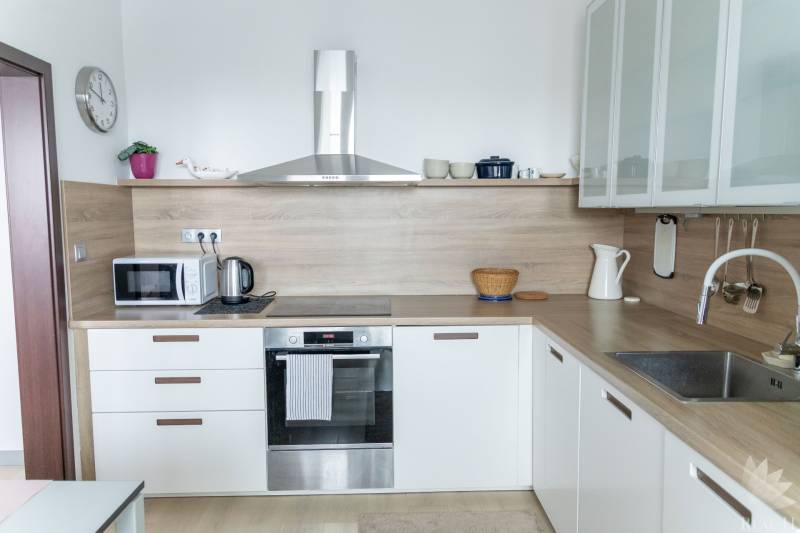 A kitchen with built-in appliances in a 4-room apartment, floor with wood decor, light-colored cabinetry.