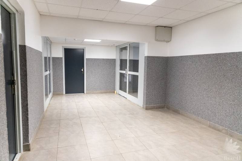 A hallway with tiles and white ceiling panels in a 4-room apartment.