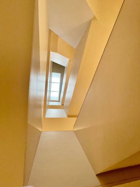 A view into the atrium of a 2-room apartment with geometric lines and a skylight.