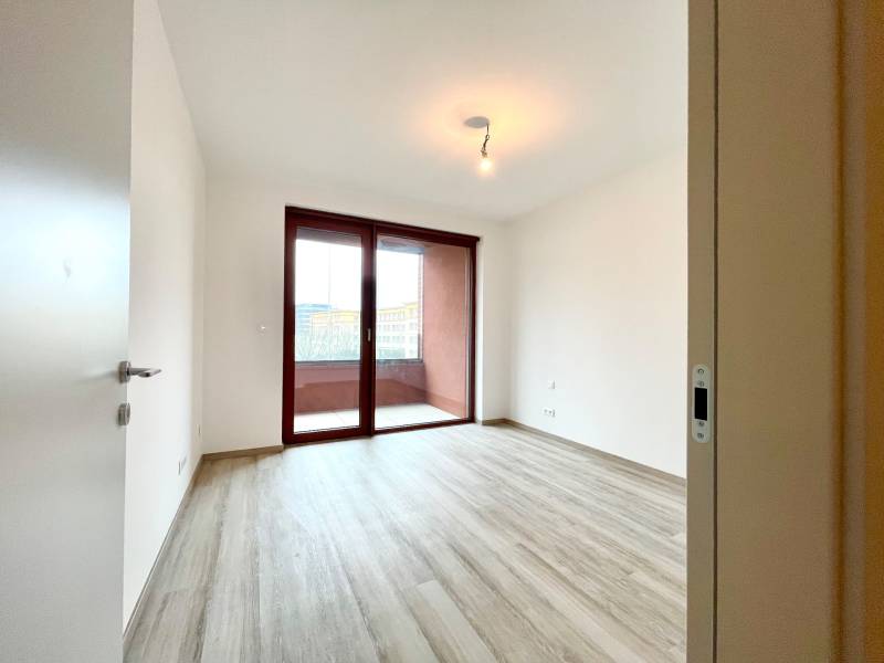 A room in a 2-room apartment with a balcony and a floor with a wood decor.