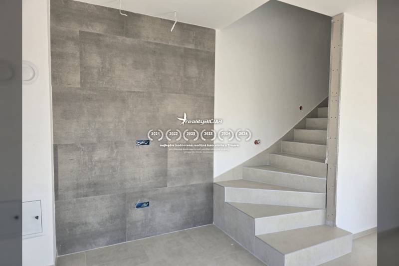 A staircase in a family house with tiles and a wall with ceramic cladding.