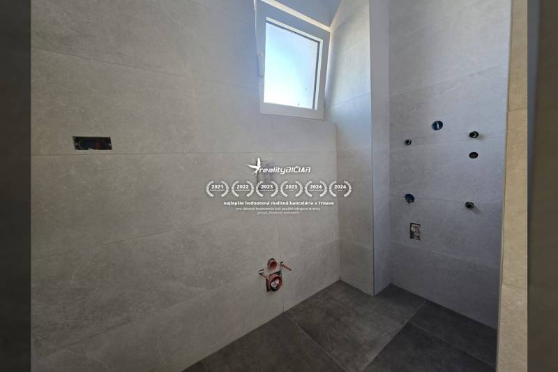 A bathroom in a family house with ceramic tiles and flooring, ready for final installation.
