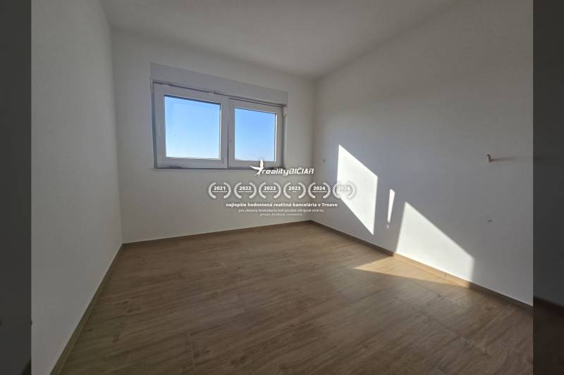 A room with a wooden floor decor in a family house, light walls, and a window.