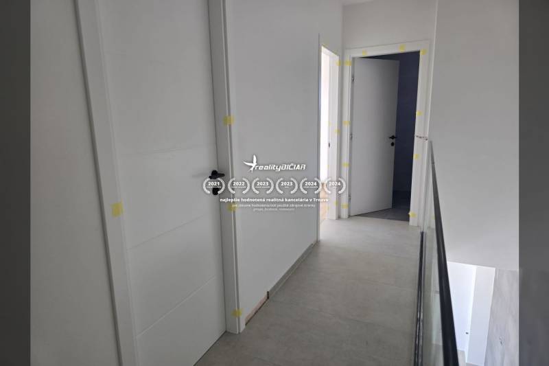 Hallway in a family house with multiple doors and light-colored walls.
