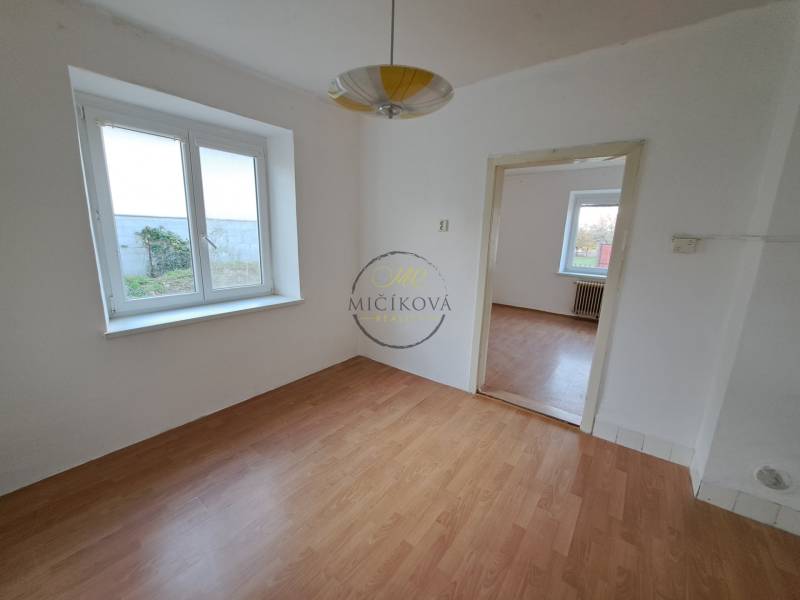 A room with white walls and a wooden decor floor in a family house.