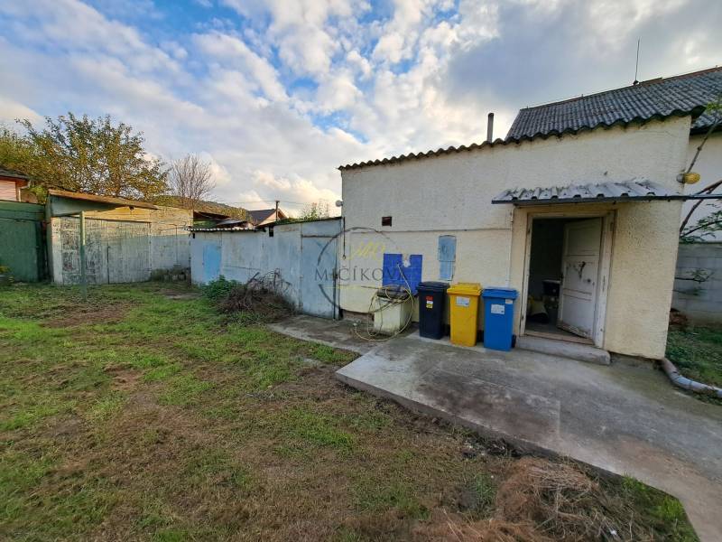 A family house on Mechenická Street in Podhorany with a yard and containers for sorted waste.