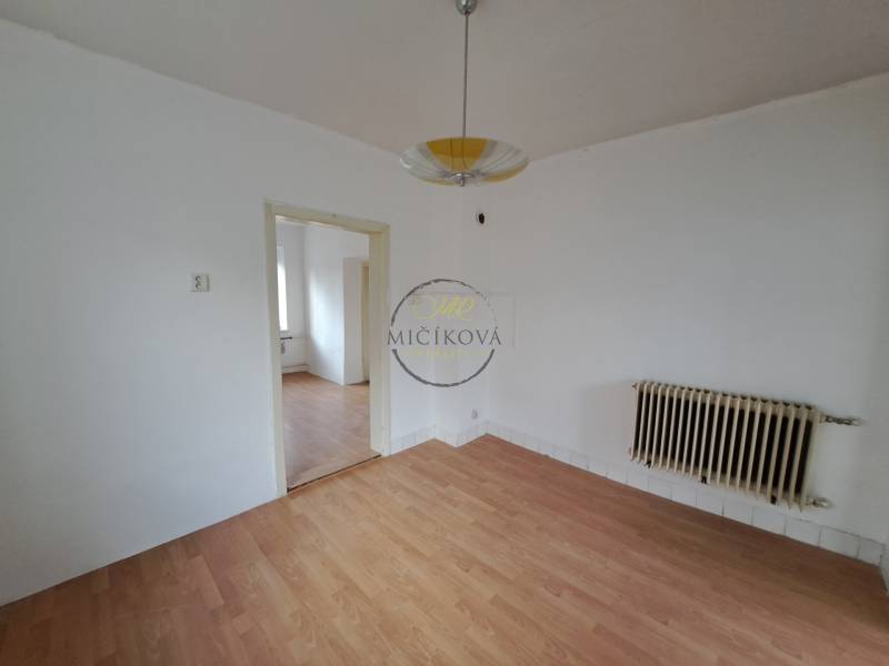 A room with white walls and a wooden decor floor in a family house.