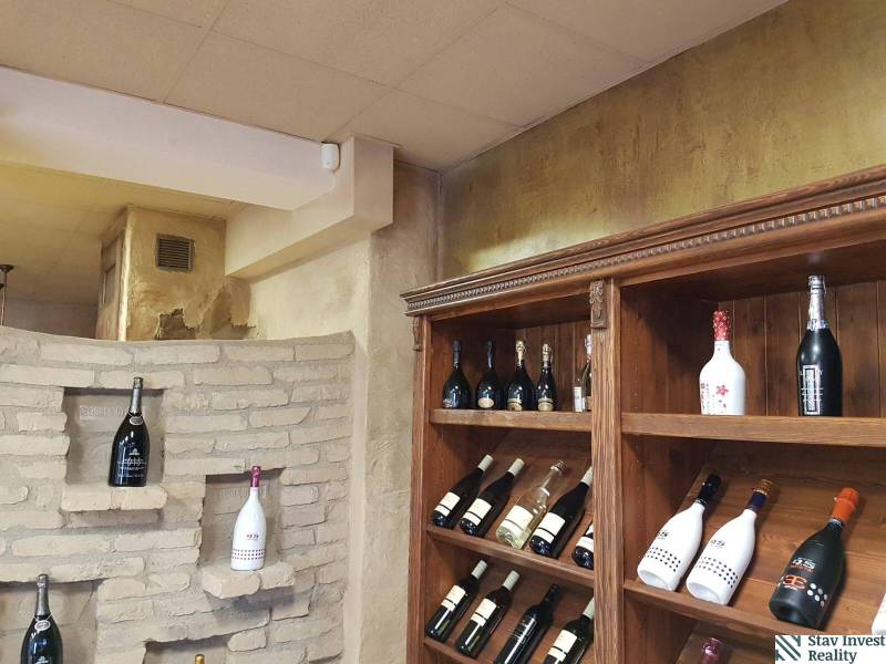Shelving racks with wine and a decorative brick wall in commercial premises.