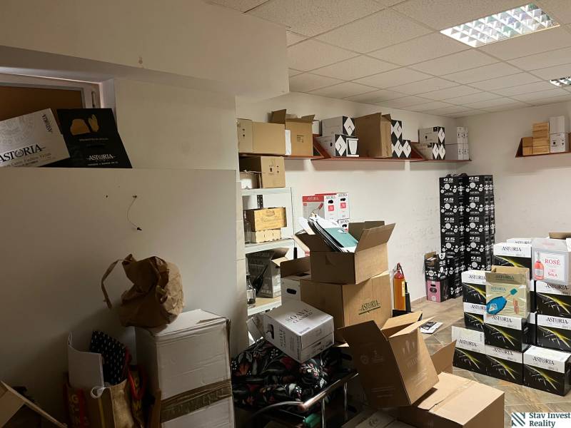 Commercial space with boxes and shelves, wooden decor flooring, white ceiling.
