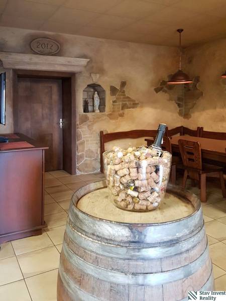 Interior of commercial premises with a wooden barrel, furniture, and a wall with decorative elements.