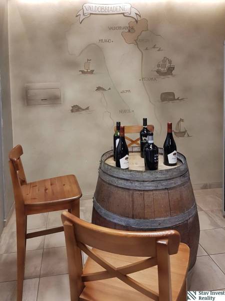 Interior scene with a wine-colored table made from a wooden barrel and a drawn map on the wall.