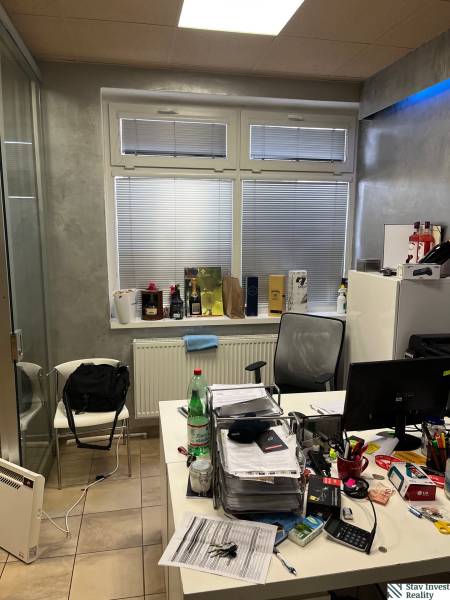 Office with a window, desk, and various office supplies in commercial premises.