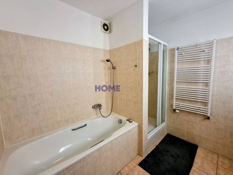 A bathroom in a 3-room apartment with a bathtub, shower, and ladder radiator.