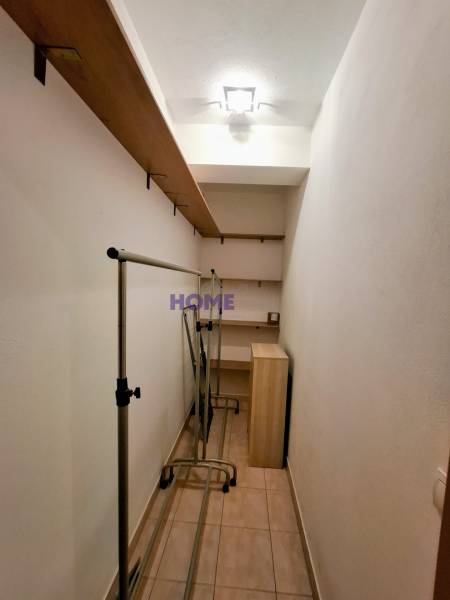 Storage space in a 3-room apartment with shelves and clothing racks.