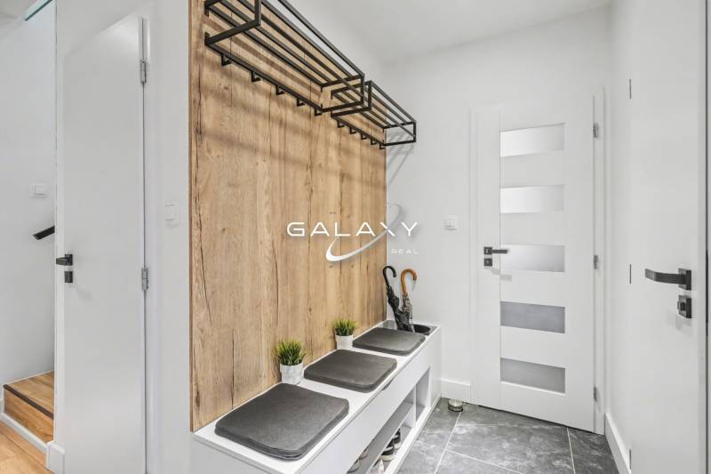 Entrance hall in a family house with a coat rack and seating with a wooden decor.