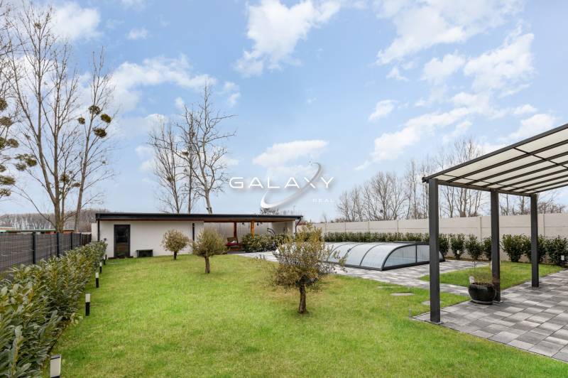 A garden at a family house in Dunajský Klátov with a gazebo and a covered swimming pool.