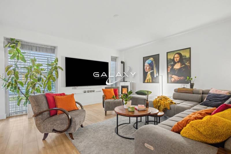 Living room of a family house with a wooden decor floor, decorative pictures, and comfortable seating.