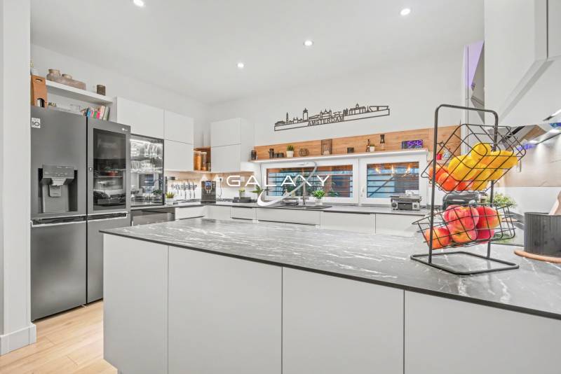 A kitchen in a family house with equipment: refrigerator, stove, and floor with wood decor.