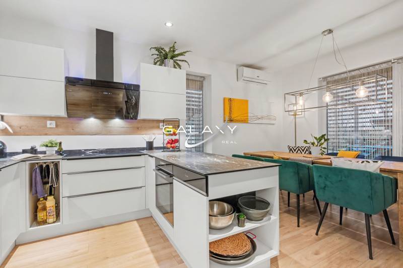 A kitchen in a family house with furnishings and a dining table, a floor with a wooden decor.