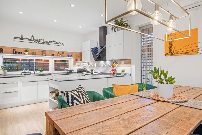 A kitchen in a family house with a wooden dining table and decoration on the shelf.