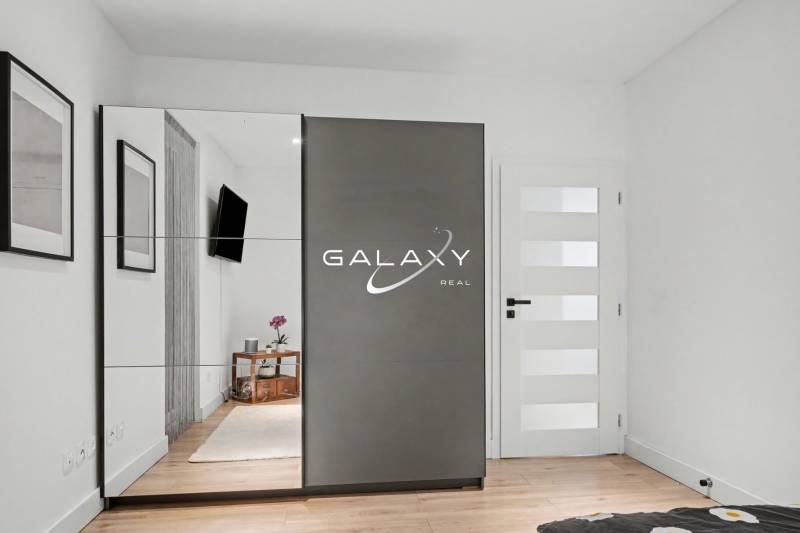 Bedroom in a family house with a built-in wardrobe and a floor with a wood decor.