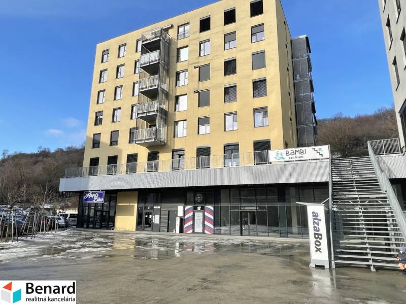 A building with commercial spaces on Prostějovská Street in Prešov under the blue sky.