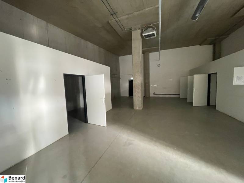 Interior of commercial premises with concrete flooring and multiple doors.