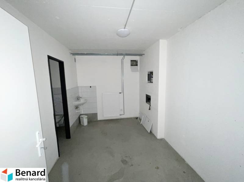 Commercial space with gray flooring, a sink, and white walls.