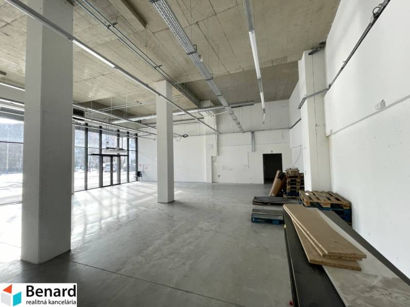 Spacious commercial spaces with large windows and high ceilings, flooring with wood decor.