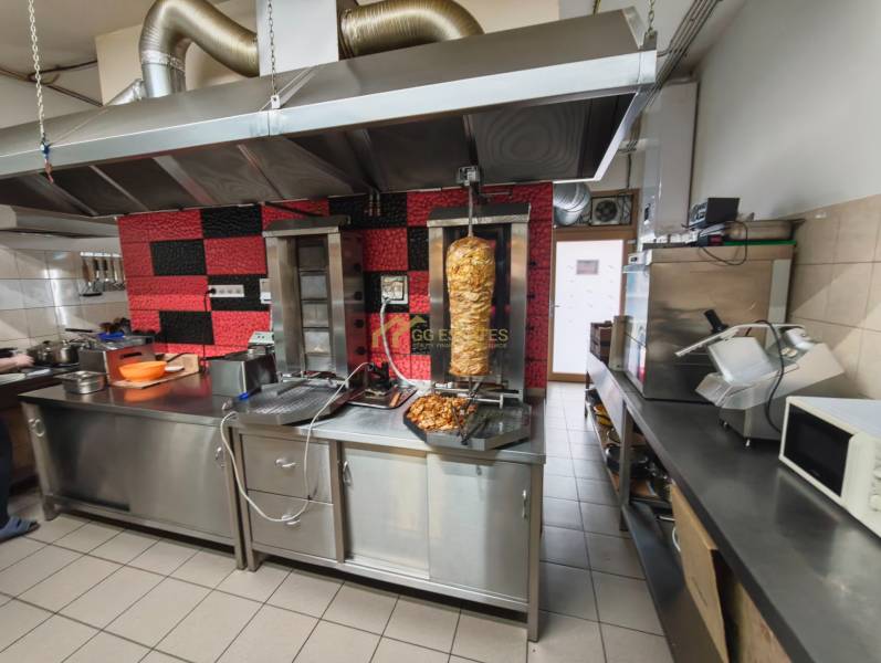 A kitchen of gastro premises with grilling equipment and stainless steel counters.