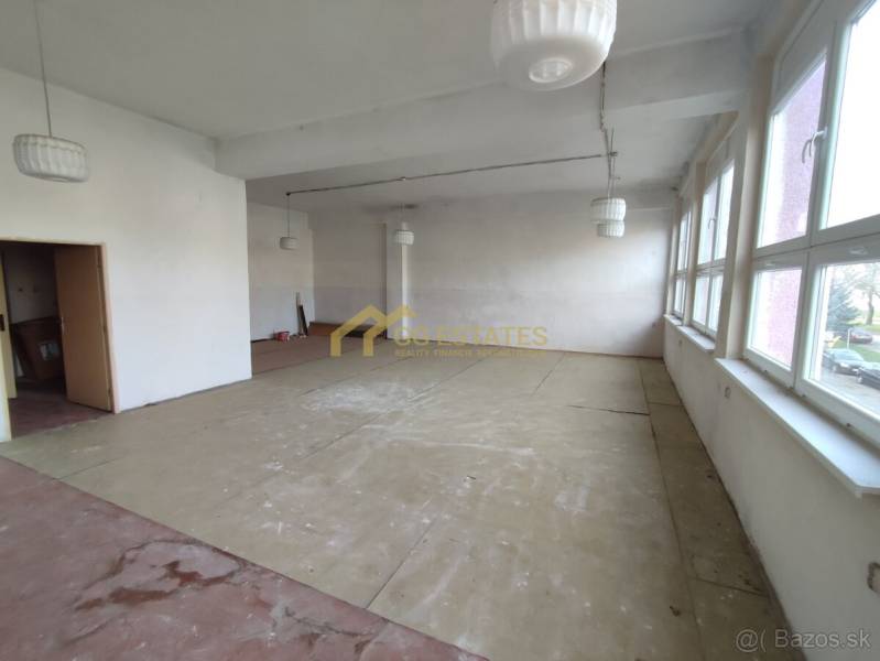 Spacious offices with large windows and wood-patterned flooring.