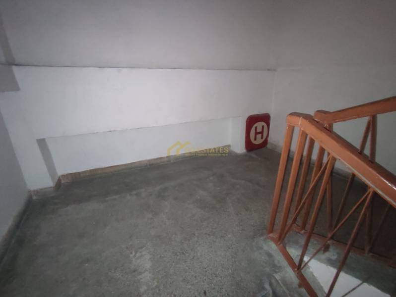 Interior of the staircase in the Office, with a railing and fire hydrant signage on the wall.