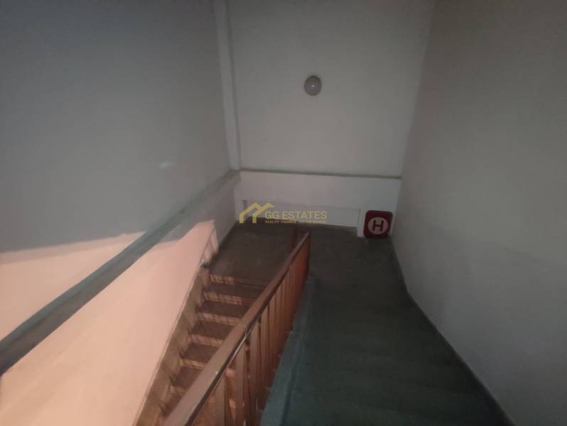 Interior of an office with a staircase and wooden railing.