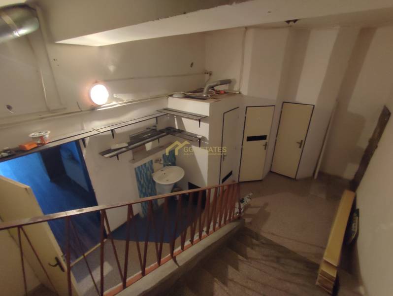 Offices with a staircase and a sink, floor with wood decor, storage space.