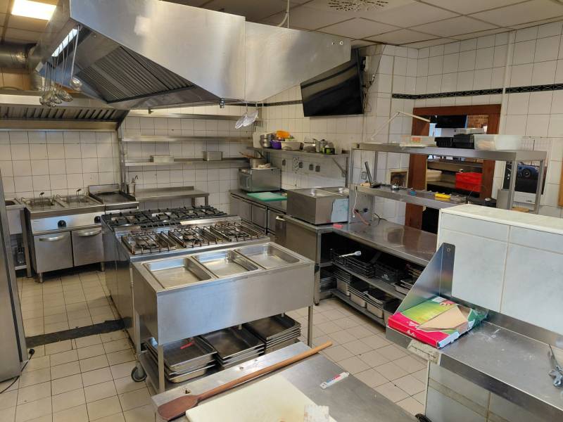 Kitchen gastro spaces with stainless steel equipment and tiled floor.