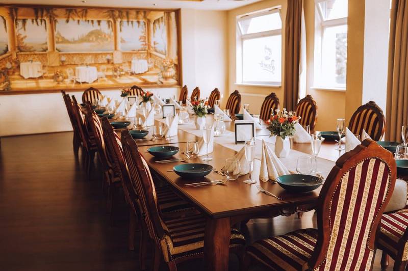 A table set for a feast, a floor with a wooden decor, a decorative wall mural.