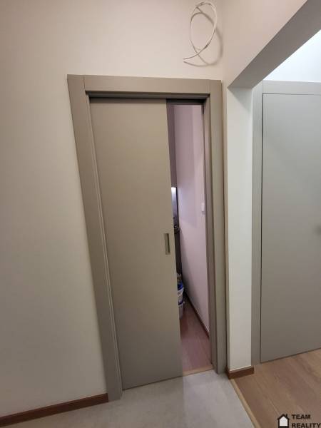 Sliding doors in a 2-room apartment with a wood-patterned floor.