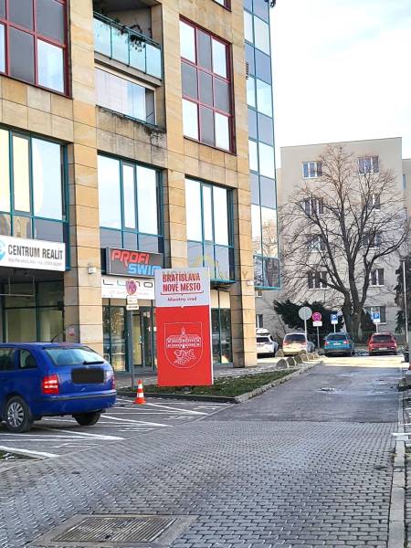 Commercial premises on Vajnorská Street in Bratislava - Nové Mesto with cars in the parking lot.