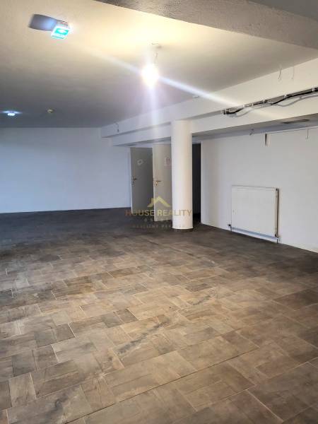 Commercial spaces with wood-patterned flooring and white walls.